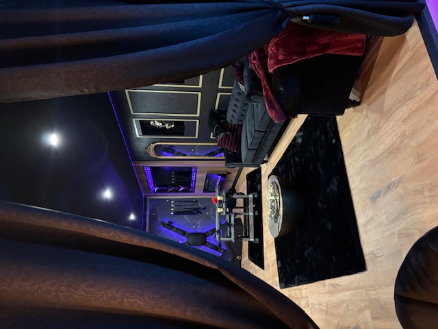 Lounge avec canapés Chesterfield, rideaux sombres et accessoires sur-mesure